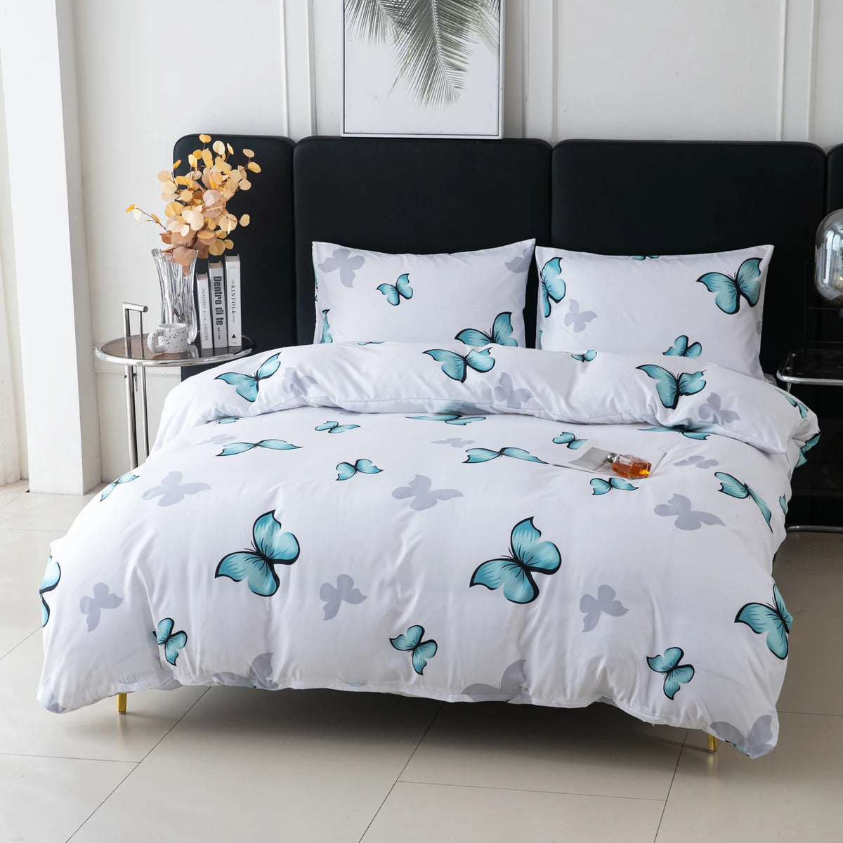 White duvet cover set with butterfly print and pillowcases displayed on a bed against a dark headboard.