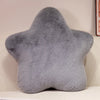A soft gray star-shaped decorative throw pillow resting on a light surface.
