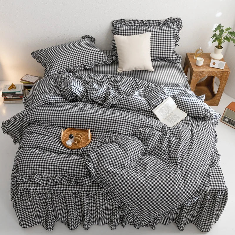 A plaid duvet cover set featuring black and white checkered fabric with ruffled edges, displayed on a bed.