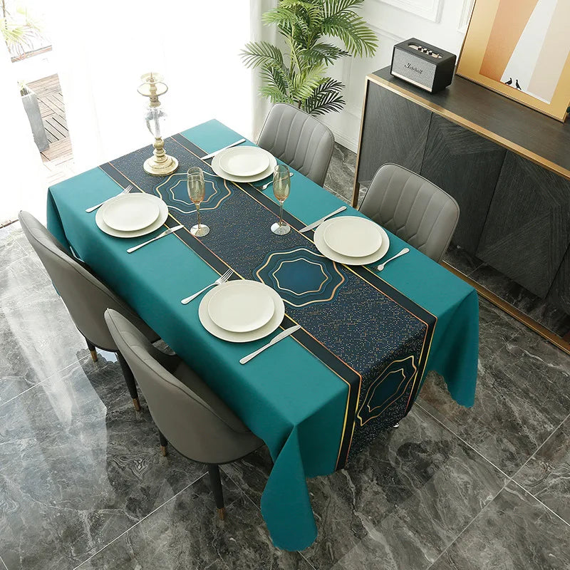 A rectangular teal tablecloth set for dining or party decor with gold accents, surrounded by gray chairs.
