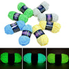 A collection of glow-in-the-dark yarn in various shades of green, blue, and yellow, packaged with labels.