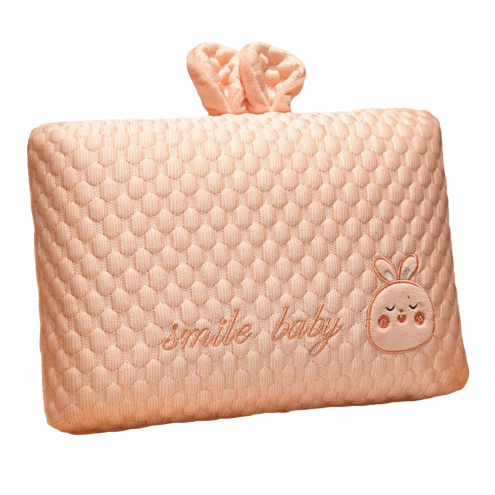 A soft peach memory foam neck pillow for toddlers with a decorative bow.