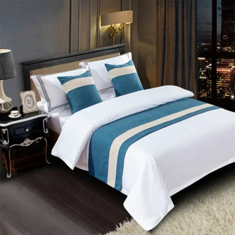 White bedding with blue and beige decorative bed flags on a modern bed.