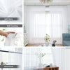 Close-up view of semi-sheer white tulle curtains with a floral texture hanging in a bright room.