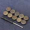A set of small, round, antique-colored metal snap buttons scattered on a dark blue fabric.