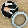 Mini precision sewing scissors with a leather protective cover and a silver ring.