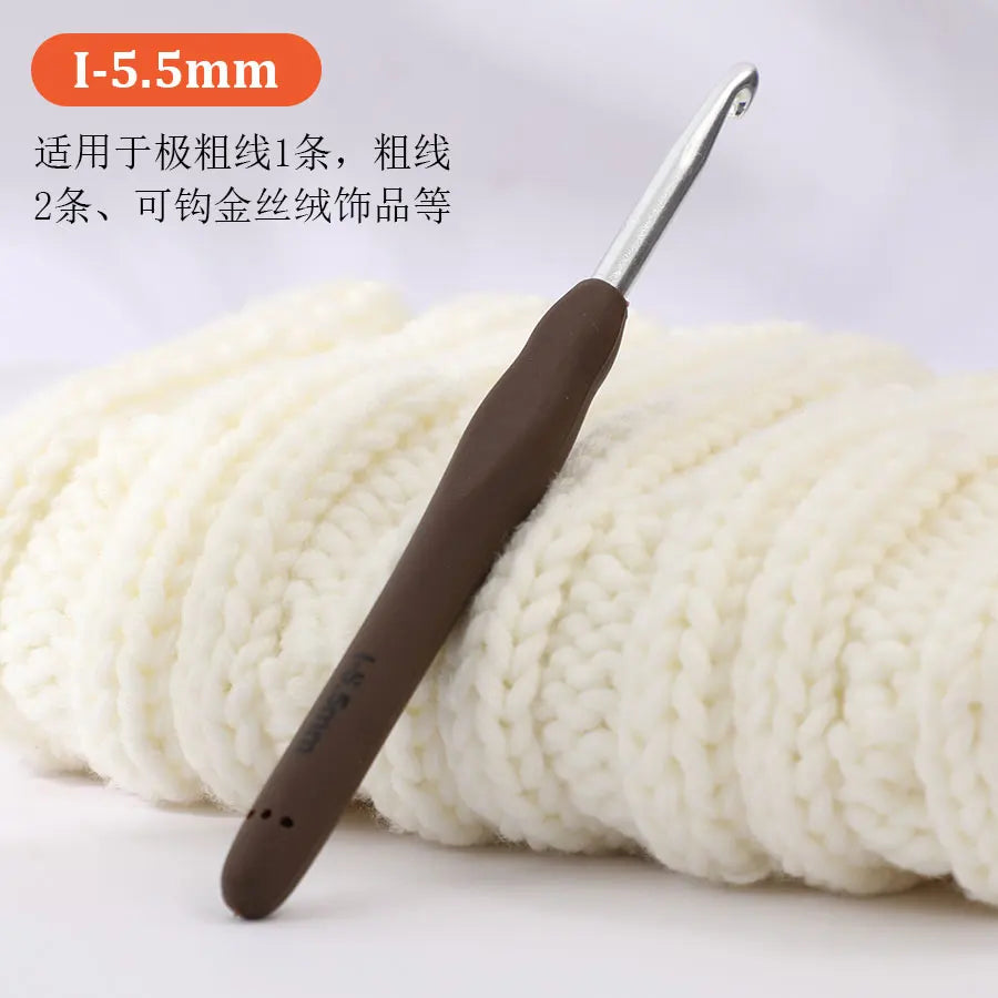 A silver precision aluminum crochet hook is shown resting on a ball of white yarn.