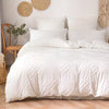 White bohemian grid tufted duvet cover set displayed on a bed with natural textures and light wood flooring.