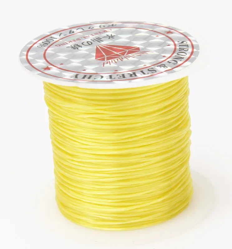 A spool of yellow multicolor elastic beading cord with a circular label featuring stars and text.