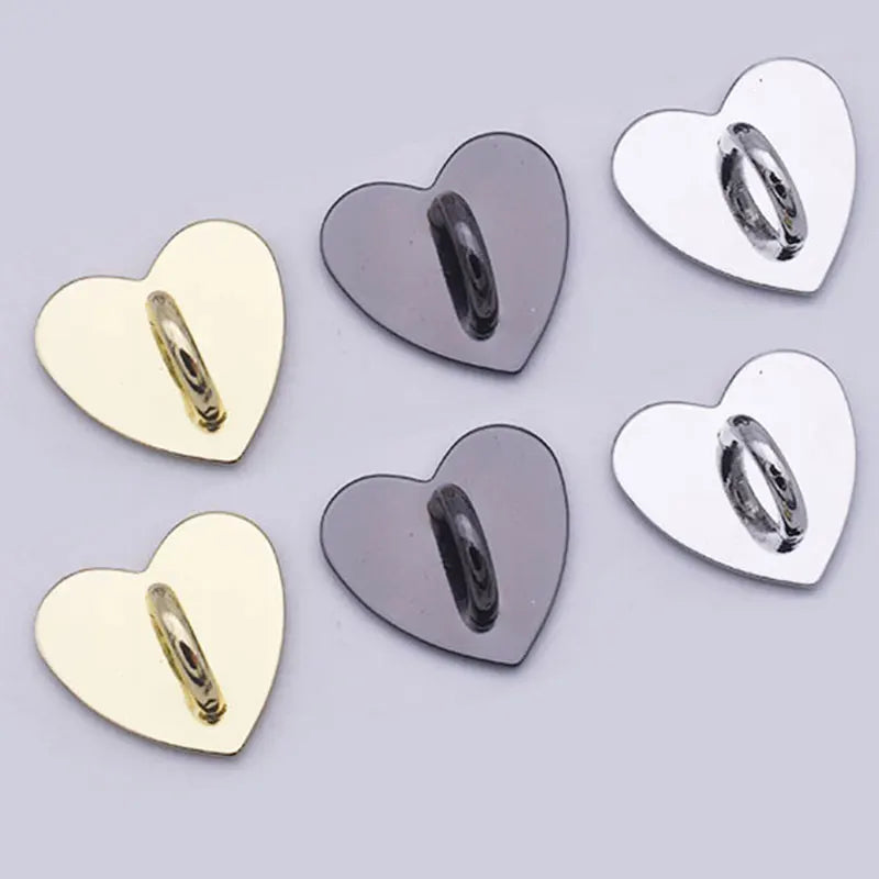A collection of shiny metal heart-shaped phone charm connectors in gold and silver tones.