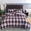 A duvet cover set featuring a geometric diamond pattern in shades of mauve and dark brown on a bed.