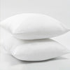 A pair of white cotton-filled decorative throw pillow inserts lying side by side.