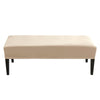 A rectangular beige velvet bench slipcover with black legs.