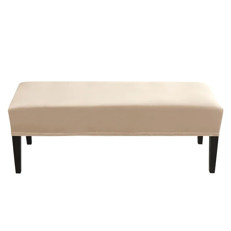 A rectangular beige velvet bench slipcover with black legs.