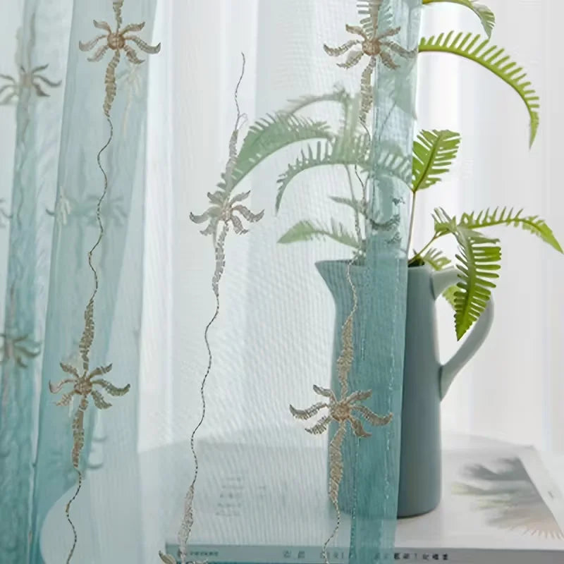 Light blue sheer curtains decorated with silver floral wave patterns and a potted green fern.