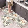 A set of two diamond print non-slip waterproof kitchen rugs placed on a light wood floor next to dark cabinets.