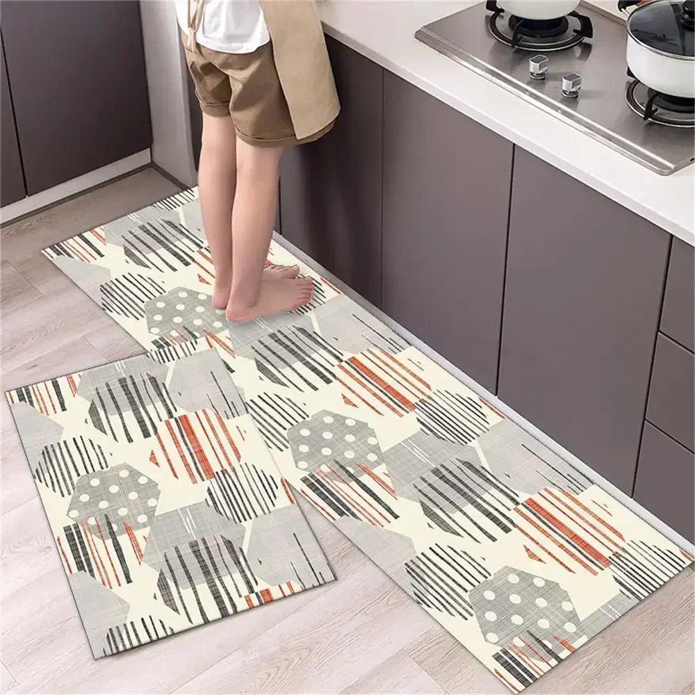 A set of two diamond print non-slip waterproof kitchen rugs placed on a light wood floor next to dark cabinets.