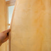 Close-up of a sheer gold blackout curtain fabric featuring a feather jacquard pattern.