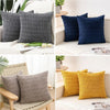 A set of two dark blue and gray knitted throw pillows displayed on a white surface.