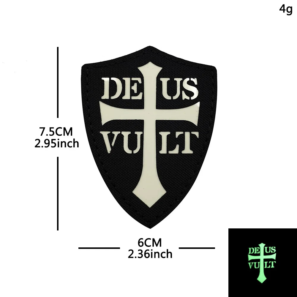 Black embroidered shield patch with a white cross and the text DEUS VULT