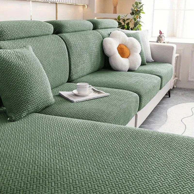 A deep green thick jacquard sofa seat cushion cover with decorative pillows and a white flower accent.