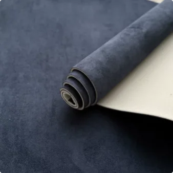 A roll of dark gray suede auto headliner fabric with a light-colored backing material.