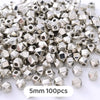 A pile of silver-toned geometric acrylic beads, approximately 5mm in size, for jewelry making.
