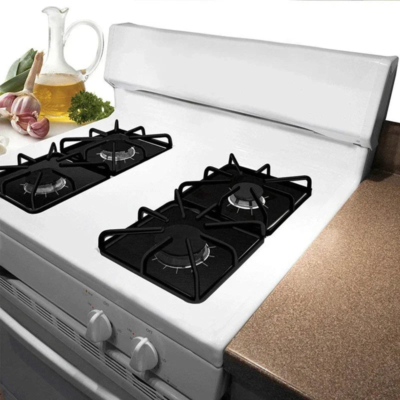A white stove burner protector mat with multiple black burners and a lid shown on a kitchen counter.