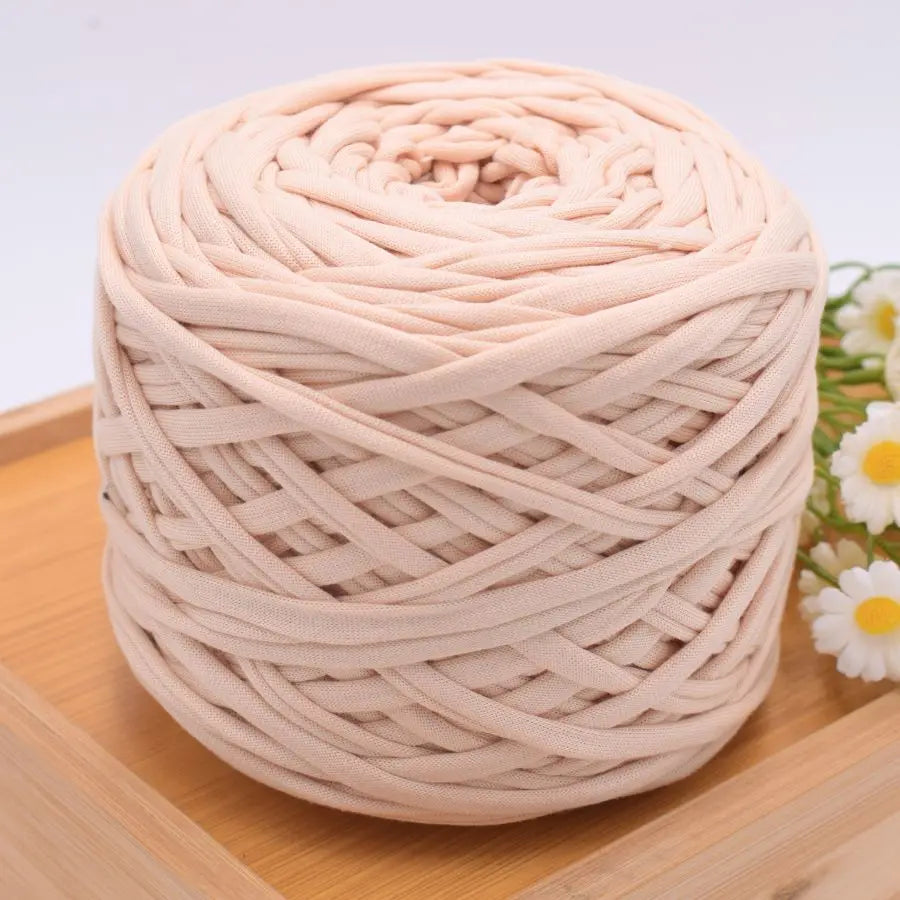 A ball of light pink craft yarn made of 100% polyester for knitting and DIY projects.