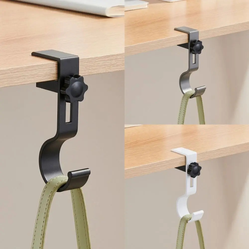 A black adjustable desk hook with dual clips is shown mounted on a wooden shelf.
