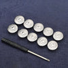 A collection of silver metal snap buttons arranged on a dark blue fabric, with an adjustable tool lying below.