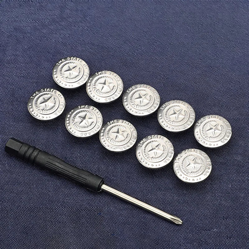 A collection of silver metal snap buttons arranged on a dark blue fabric, with an adjustable tool lying below.