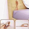 A close-up view of a rose gold mattress lifter wedge used for easy bedding changes.
