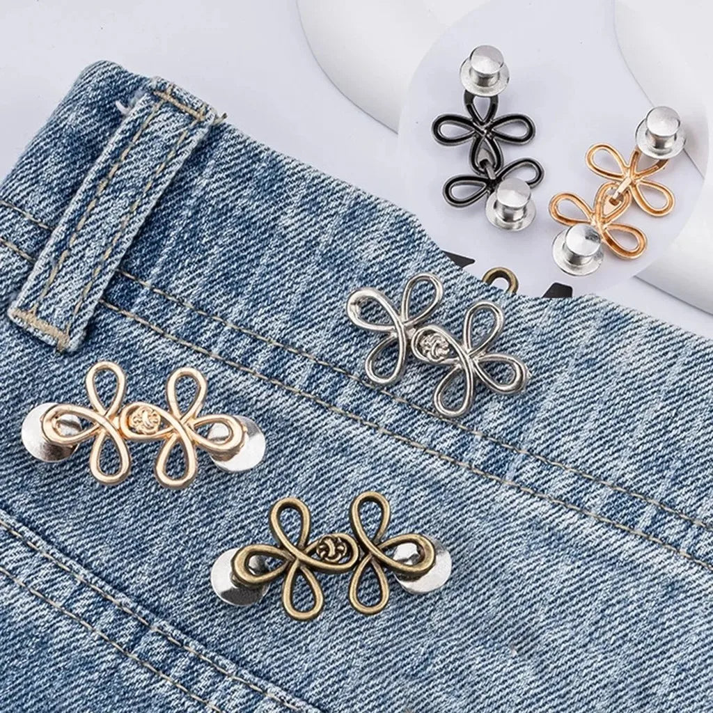 Gold and silver adjustable leaf clover fabric fasteners attached to a denim jean pocket