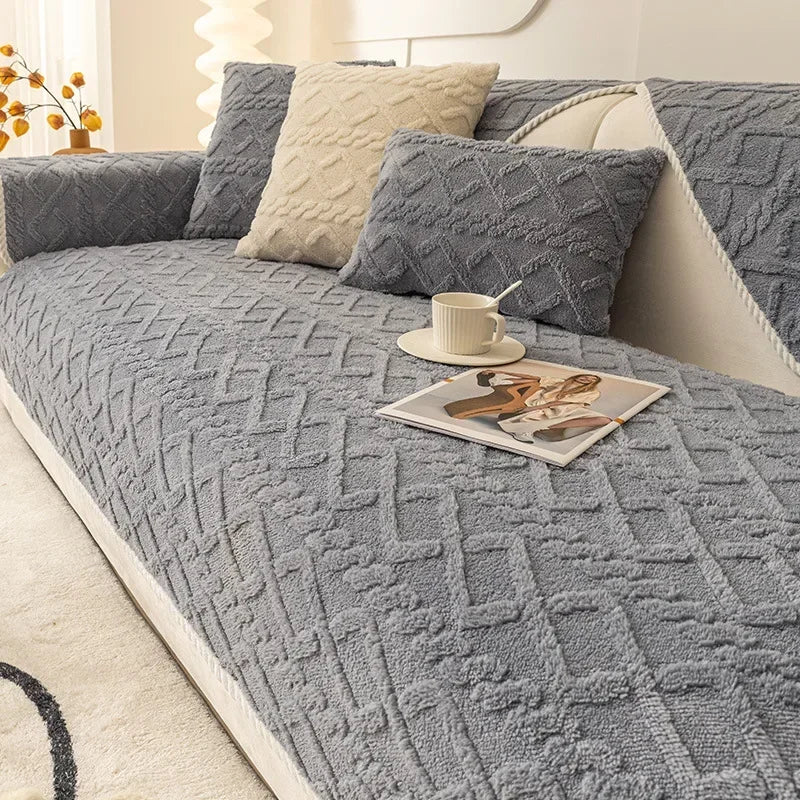A gray plush winter sofa cushion cover with textured fabric and cream accent pillows on a sofa.