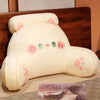 A cream-colored plush sofa cushion shaped like a cute animal with pink and green facial features.
