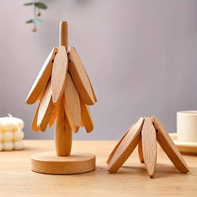 A wooden placemat with a stylized leaf design stands upright on a light wood table.