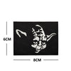 Black embroidered patch featuring a white stylized face design on a black fabric background