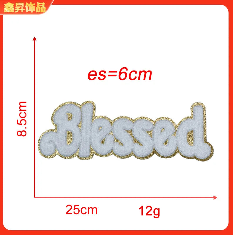 A line of white felt embroidery patches spelling the word Blessed with a gold outline