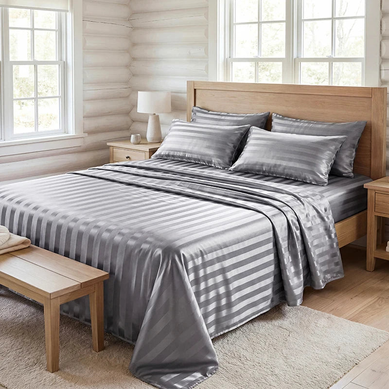 A bed dressed with gray and white striped wrinkle-resistant satin bedding set in a bright bedroom.