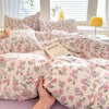 A light pink duvet cover featuring a floral pattern with purple and pink flowers.