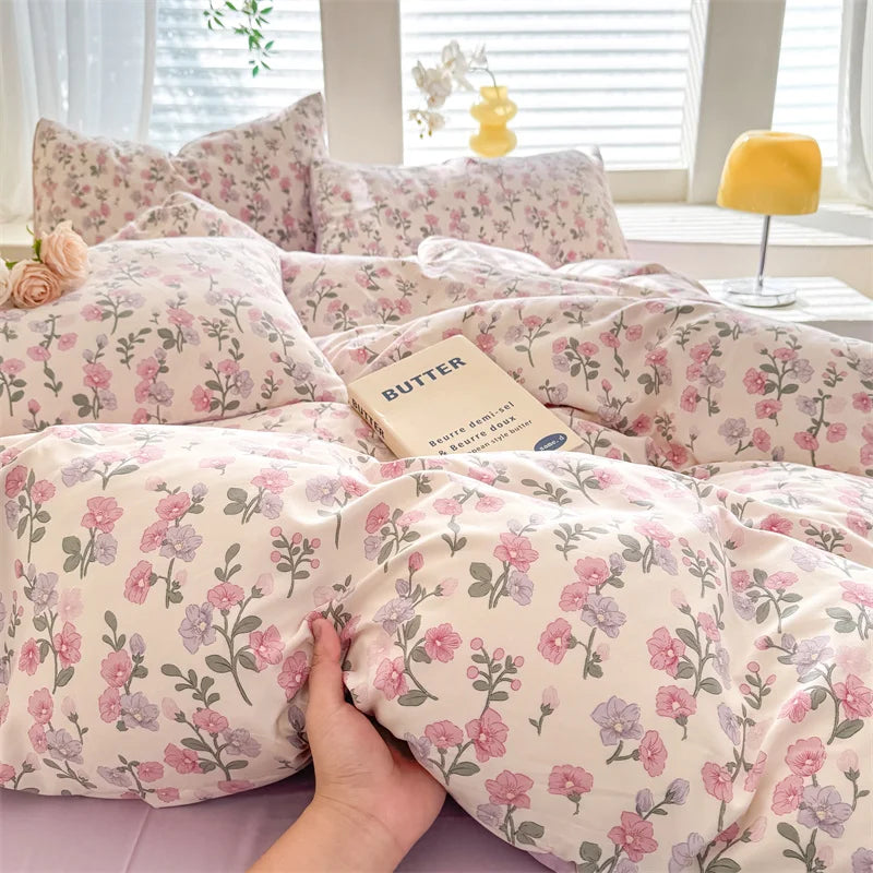 A light pink duvet cover featuring a floral pattern with purple and pink flowers.