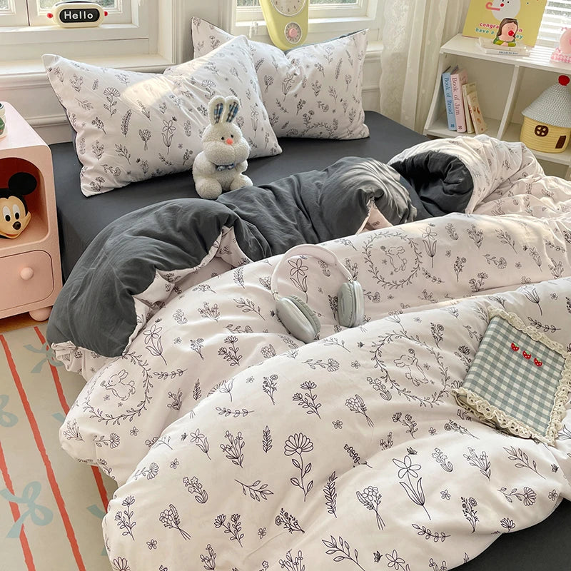 A set of white and gray ultra-soft microfiber duvet covers and pillowcases displayed on a bed.