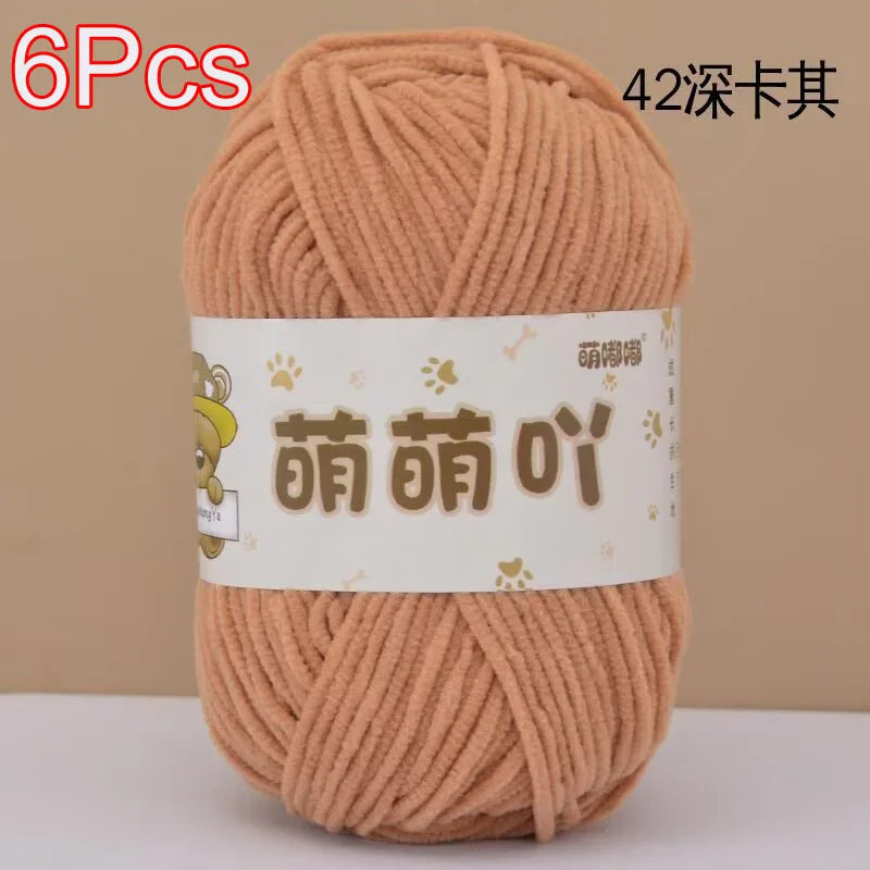 A skein of soft, bulky, light peach colored chenille yarn is shown in a ball.