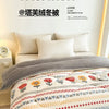 A cozy bed with a thick gray blanket featuring floral patterns and white pillows.