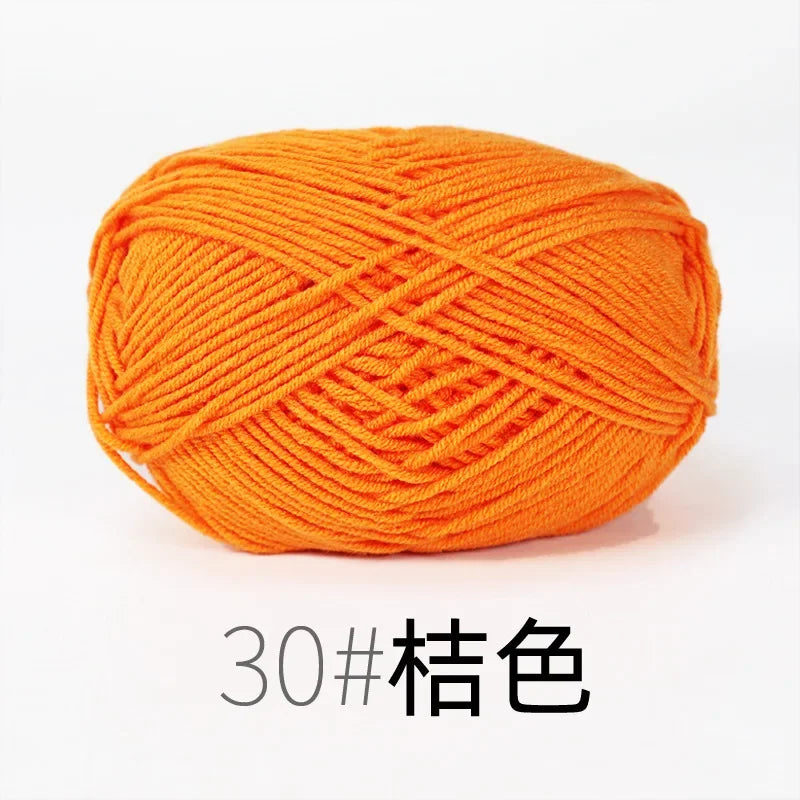A ball of bright orange organic cotton 4ply knitting yarn for crafts.