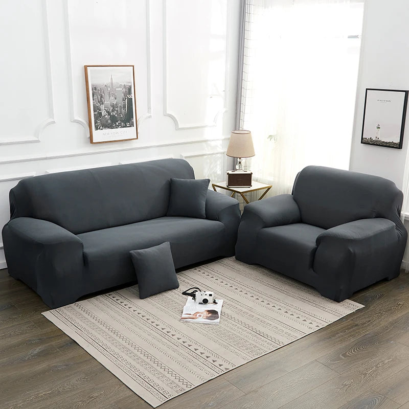 A modern gray faux silk sofa cover displayed on a light wood coffee table in a bright living room setting.