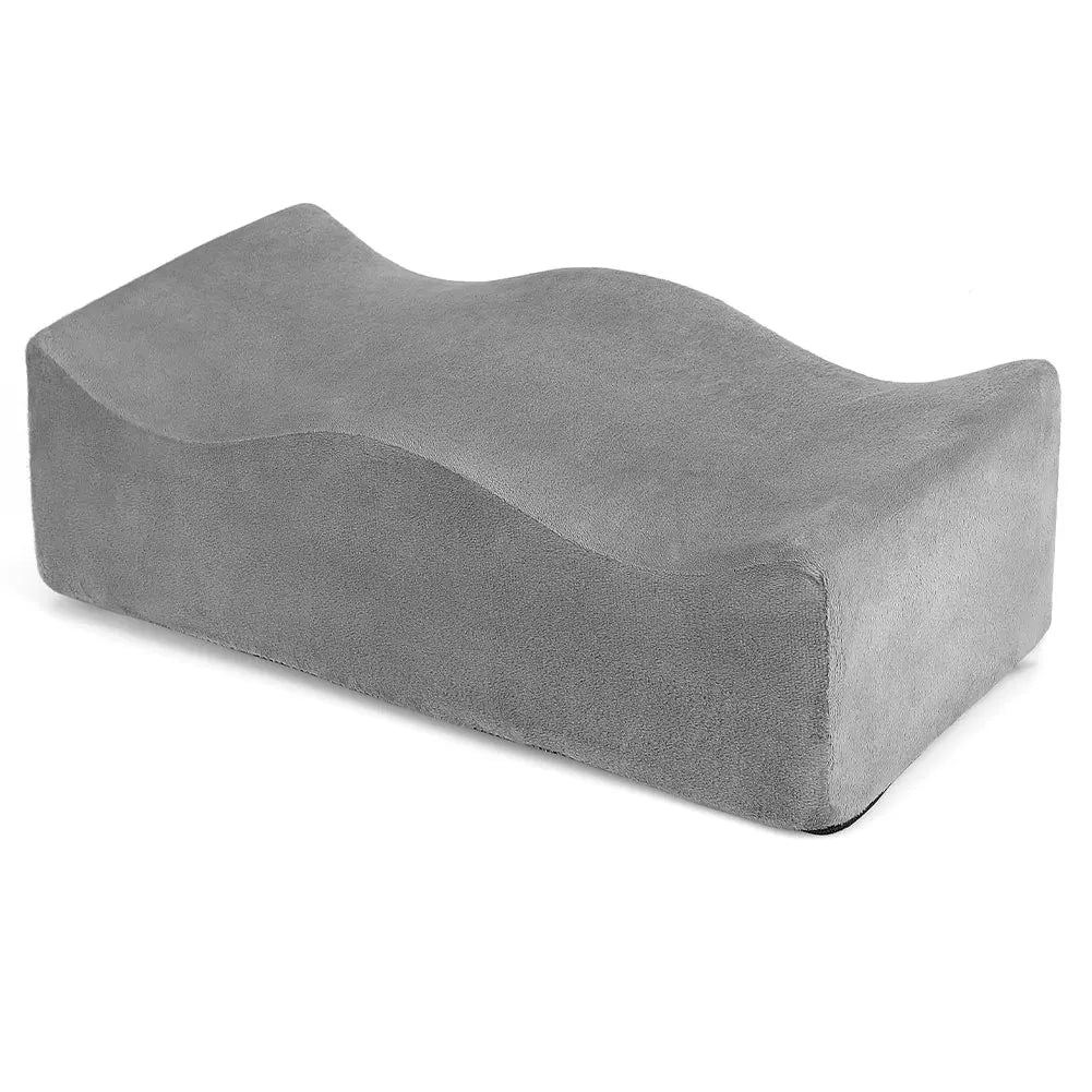 A gray ergonomic seat cushion designed for tailbone relief and hip support.