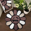A dark brown and white textured sunflower bathroom mat resting on a wooden floor.