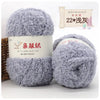 Two balls of soft gray coral velvet yarn for crafting displayed next to a label and a cactus.